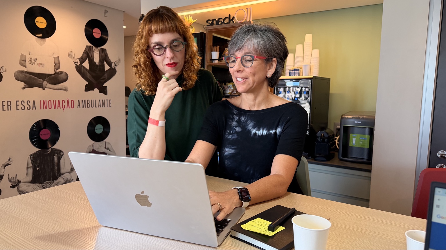 Mari e uma participante pensando juntas diante de um computador